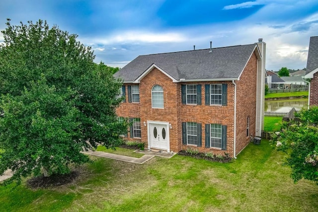 784 Lakeview Ln, Covington, LA 70435 - colonial home featuring a chimney, a shingled roof, brick siding, and a front yard