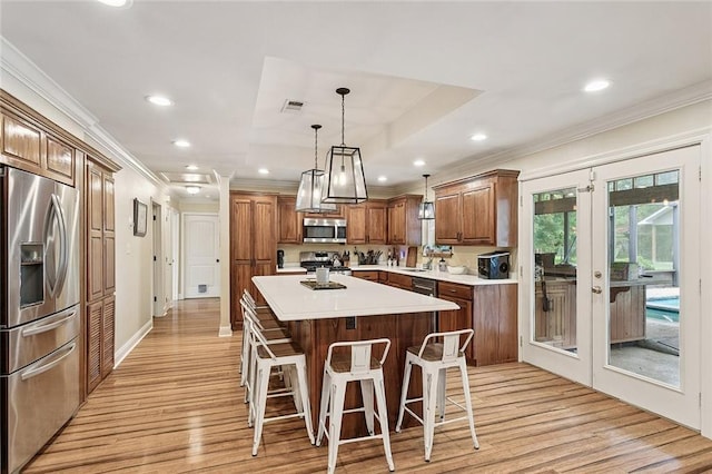 540 N 8th St, Ponchatoula, LA 70454 - kitchen featuring appliances with stainless steel finishes, crown molding, light wood-type flooring, light countertops, and a kitchen breakfast bar
