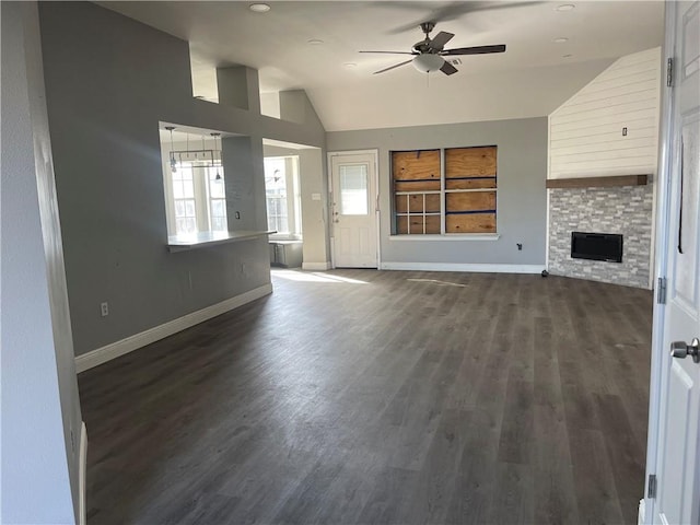 40 Cane Dr, La Place, LA 70068 - unfurnished living room featuring vaulted ceiling, ceiling fan, dark wood-style flooring, and a stone fireplace