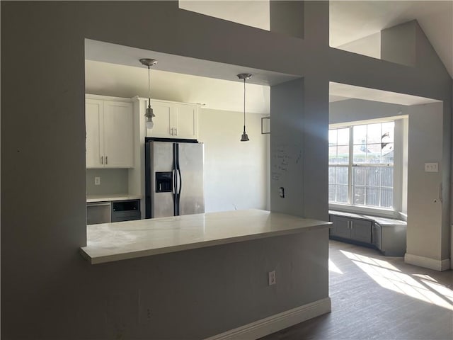 40 Cane Dr, La Place, LA 70068 - kitchen with stainless steel fridge with ice dispenser, hanging light fixtures, white cabinetry, light countertops, and wood finished floors