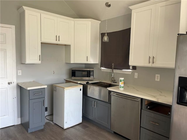 40 Cane Dr, La Place, LA 70068 - kitchen featuring appliances with stainless steel finishes, dark wood finished floors, light stone counters, gray cabinets, and lofted ceiling