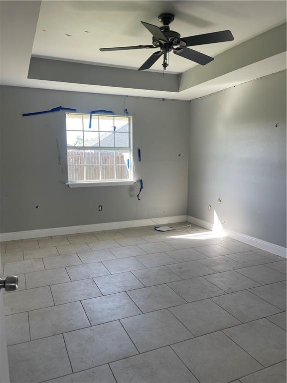 40 Cane Dr, La Place, LA 70068 - tiled empty room featuring a raised ceiling and a ceiling fan
