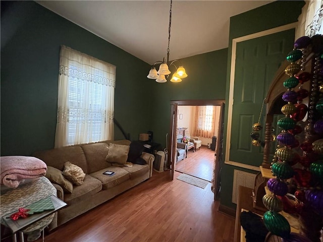 3120 Urquhart St, New Orleans, LA 70117 - living room featuring wood finished floors, a chandelier, and vaulted ceiling