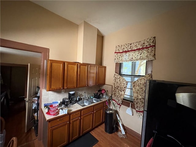 3120 Urquhart St, New Orleans, LA 70117 - kitchen featuring freestanding refrigerator, brown cabinetry, tile countertops, decorative backsplash, and lofted ceiling