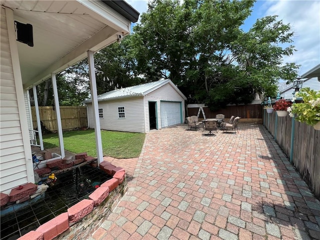 3821 Derbigny St, Metairie, LA 70001 - fenced backyard featuring an outdoor structure, a detached garage, a patio area, and driveway