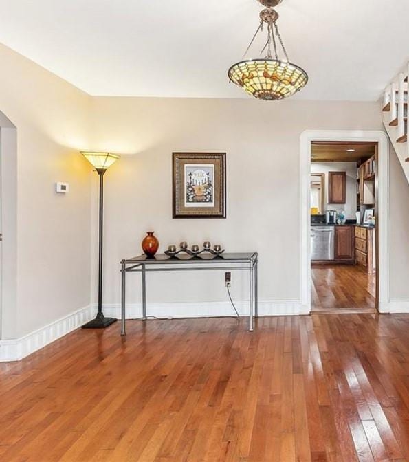 3821 Derbigny St, Metairie, LA 70001 - dining room with hardwood / wood-style flooring, stairway, and arched walkways