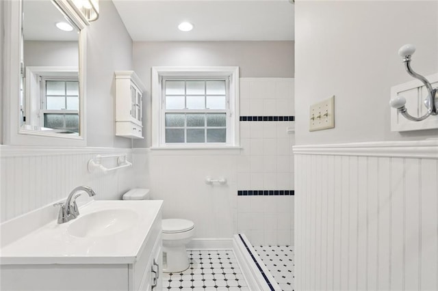 4827 Utica St, Metairie, LA 70006 - bathroom featuring vanity, walk in shower, a wainscoted wall, plenty of natural light, and tile patterned floors