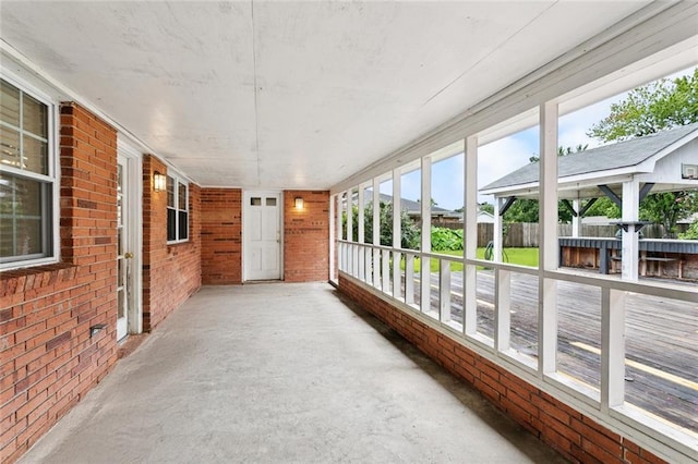 4827 Utica St, Metairie, LA 70006 - unfurnished sunroom featuring concrete floors and brick wall
