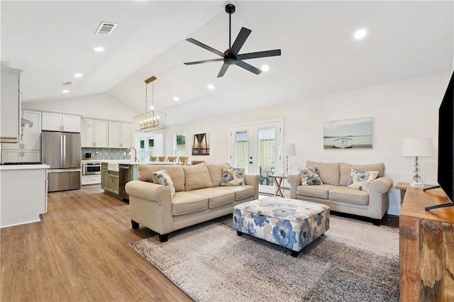 1109 Manson St, Metairie, LA 70001 - living area featuring vaulted ceiling, light wood-style flooring, a ceiling fan, french doors, and recessed lighting