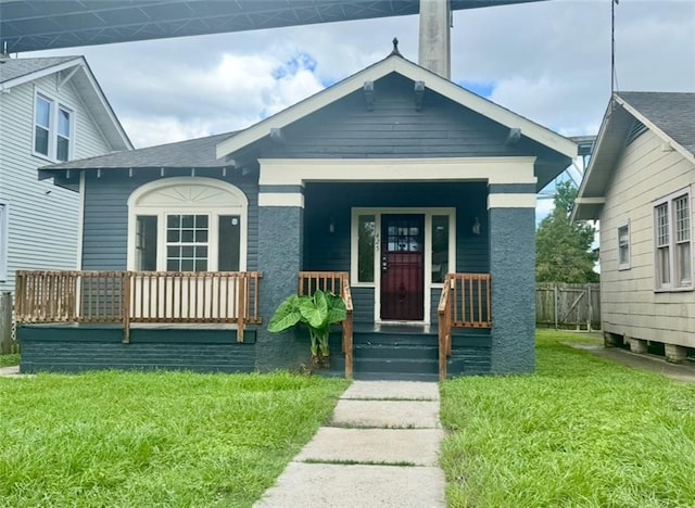 425 Park Blvd, New Orleans, LA 70114 - view of front of house with covered porch, a front lawn, and a shingled roof