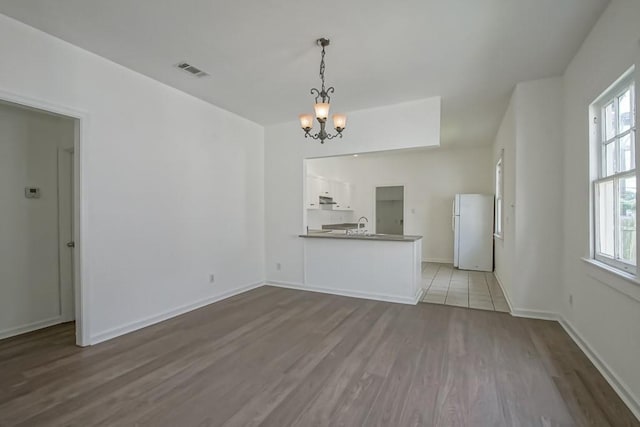 425 Park Blvd, New Orleans, LA 70114 - unfurnished living room with wood finished floors and a chandelier