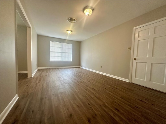 8732 25th St, Metairie, LA 70003 - empty room featuring dark wood-type flooring and baseboards