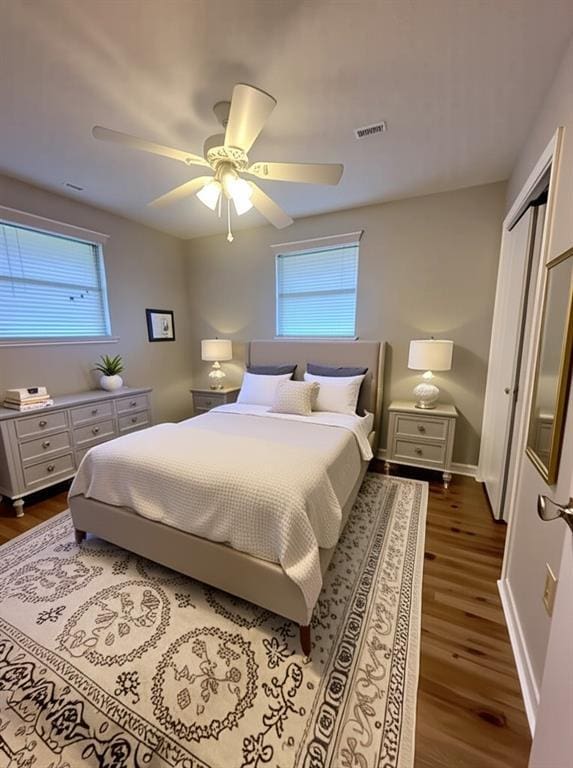 8732 25th St, Metairie, LA 70003 - bedroom featuring dark wood-style flooring, multiple windows, ceiling fan, and a closet
