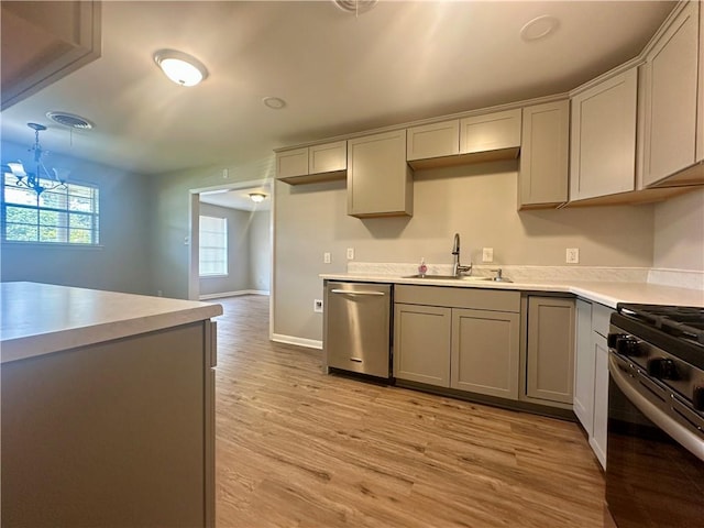 8732 25th St, Metairie, LA 70003 - kitchen featuring stainless steel dishwasher, range, light countertops, light wood-style flooring, and gray cabinets