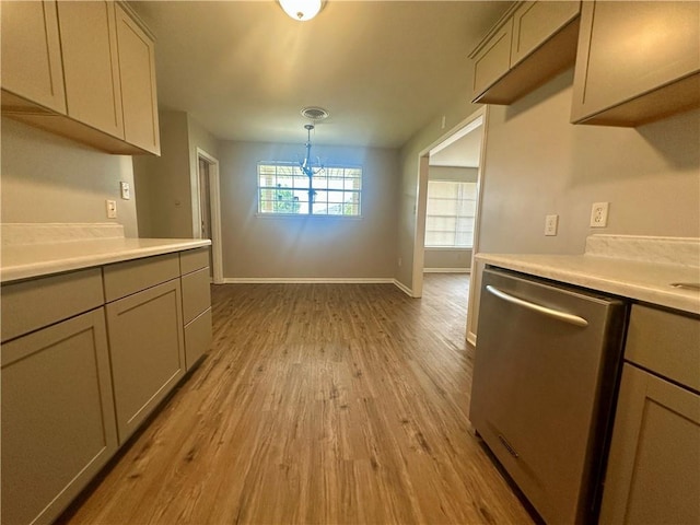 8732 25th St, Metairie, LA 70003 - kitchen with stainless steel dishwasher, wood finished floors, light countertops, and gray cabinetry