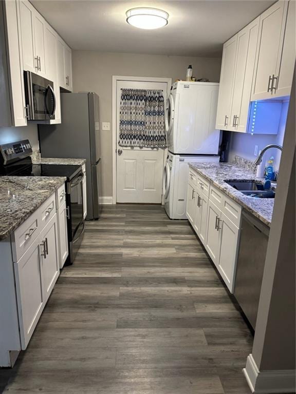 1905 Farmington Pl, Gretna, LA 70056 - kitchen with appliances with stainless steel finishes, estacked washer and dryer, dark wood-style floors, and white cabinetry