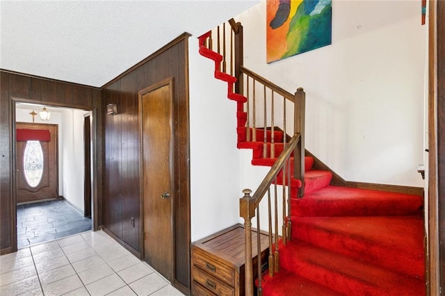 3125 Metairie Ct, Metairie, LA 70002 - stairway featuring wooden walls, tile patterned flooring, and a textured ceiling