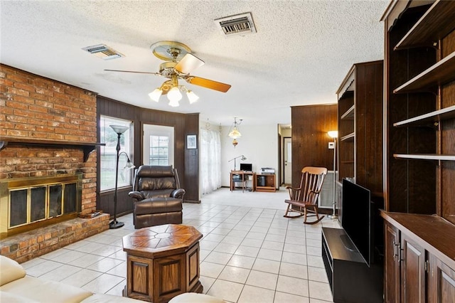 3125 Metairie Ct, Metairie, LA 70002 - living area with ceiling fan, light tile patterned floors, a textured ceiling, a fireplace, and wooden walls