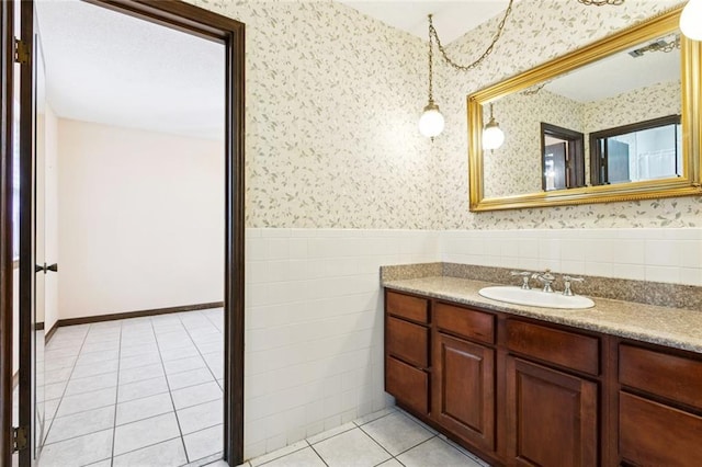 3125 Metairie Ct, Metairie, LA 70002 - bathroom featuring wallpapered walls, vanity, wainscoting, tile patterned flooring, and tile walls