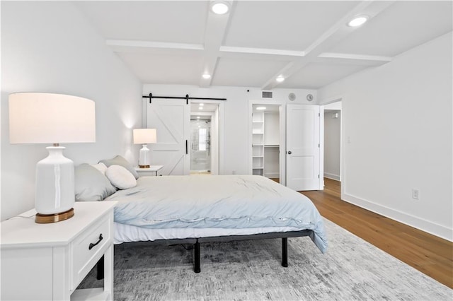 300 Lake Marina Ave Unit 7-C, New Orleans, LA 70124 - bedroom featuring wood finished floors, a barn door, beamed ceiling, recessed lighting, and coffered ceiling