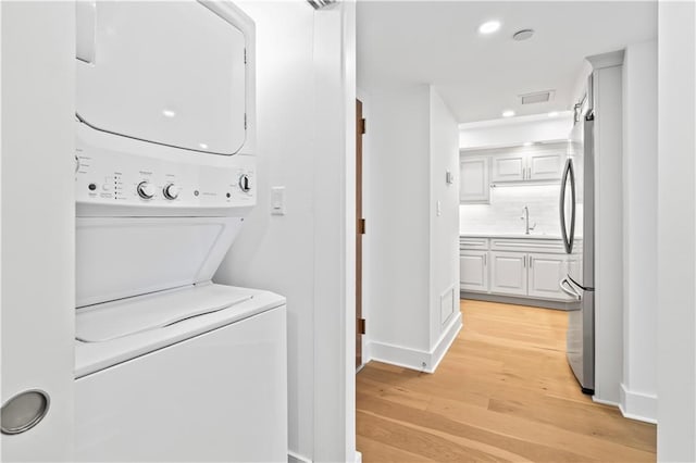300 Lake Marina Ave Unit 7-C, New Orleans, LA 70124 - laundry area featuring stacked washer / dryer, light wood-style floors, and recessed lighting