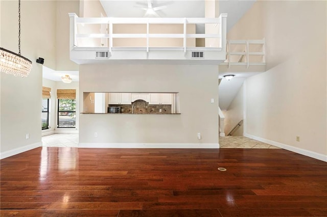 26 Chamale Cv Unit 26, Slidell, LA 70460 - unfurnished living room with a high ceiling, light wood-type flooring, a chandelier, and a ceiling fan