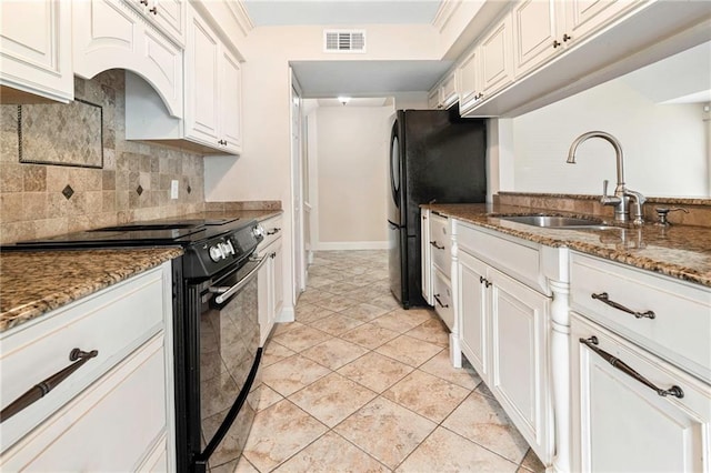 26 Chamale Cv Unit 26, Slidell, LA 70460 - kitchen with black appliances, decorative backsplash, dark stone countertops, white cabinets, and custom exhaust hood