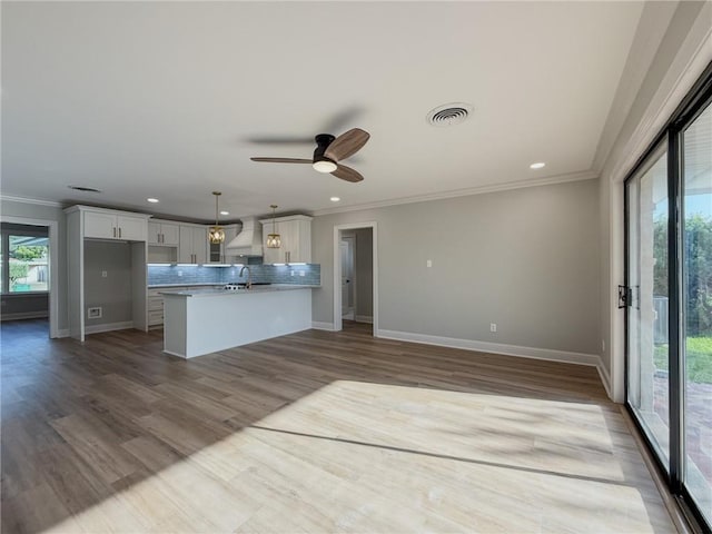861 W William David Pkwy, Metairie, LA 70005 - kitchen with ornamental molding, custom range hood, white cabinets, backsplash, and recessed lighting