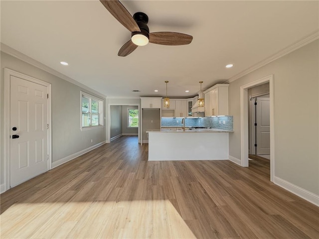 861 W William David Pkwy, Metairie, LA 70005 - kitchen featuring crown molding, white cabinets, a peninsula, ceiling fan, and backsplash