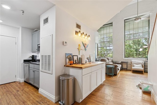 920 Poeyfarre St Unit 326, New Orleans, LA 70130 - kitchen featuring dishwasher, light wood-type flooring, butcher block counters, hanging light fixtures, and gray cabinets