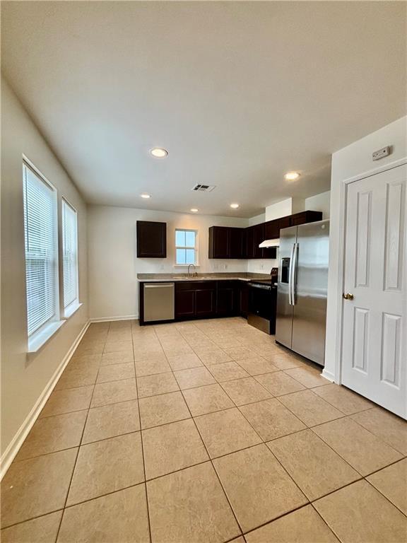 70330 C St, Covington, LA 70433 - kitchen with appliances with stainless steel finishes, light tile patterned flooring, recessed lighting, light countertops, and under cabinet range hood