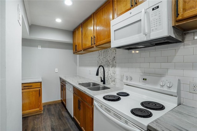 4218 Hessmer Ave Unit 217, Metairie, LA 70002 - kitchen featuring white appliances, brown cabinets, light countertops, dark wood-style floors, and decorative backsplash