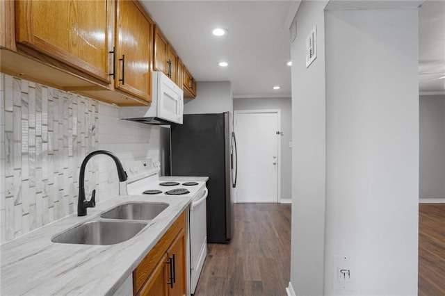 4218 Hessmer Ave Unit 217, Metairie, LA 70002 - kitchen with white appliances, ornamental molding, brown cabinets, recessed lighting, and backsplash