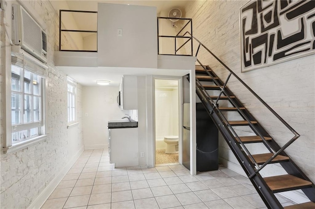 1133 Royal St Unit 7, New Orleans, LA 70116 - staircase with tile patterned floors, a towering ceiling, and a wall mounted AC
