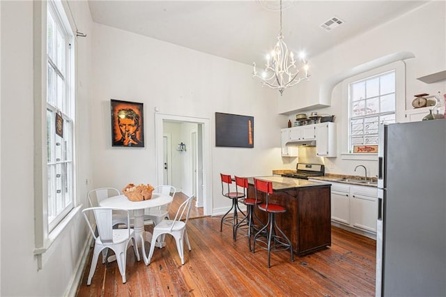 1821 Urquhart St, New Orleans, LA 70116 - kitchen featuring appliances with stainless steel finishes, a center island, a chandelier, and white cabinets