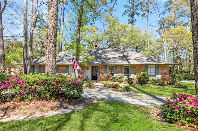 124 N Dr, Covington, LA 70433 - view of front of house with a front lawn, a chimney, and brick siding