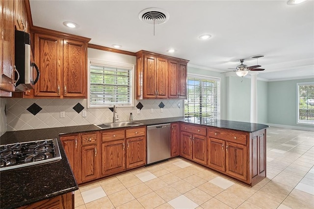 124 N Dr, Covington, LA 70433 - kitchen featuring stainless steel appliances, crown molding, a peninsula, brown cabinetry, and tasteful backsplash