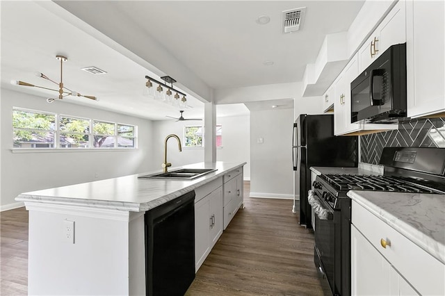 513 Roseland Pkwy, Harahan, LA 70123 - kitchen featuring black appliances, an island with sink, light countertops, white cabinetry, and dark wood-type flooring