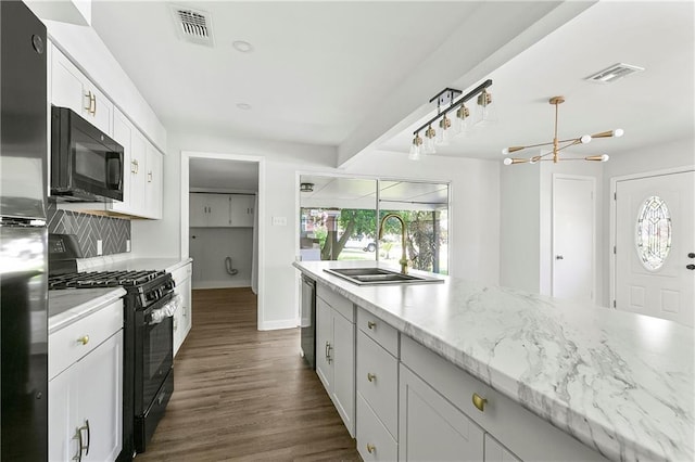 513 Roseland Pkwy, Harahan, LA 70123 - kitchen featuring black appliances, a chandelier, white cabinets, dark wood-style floors, and light stone countertops