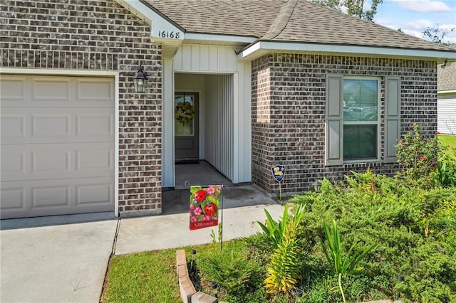 16168 S Trace Ext, Ponchatoula, LA 70454 - view of exterior entry featuring a shingled roof, an attached garage, brick siding, and concrete driveway