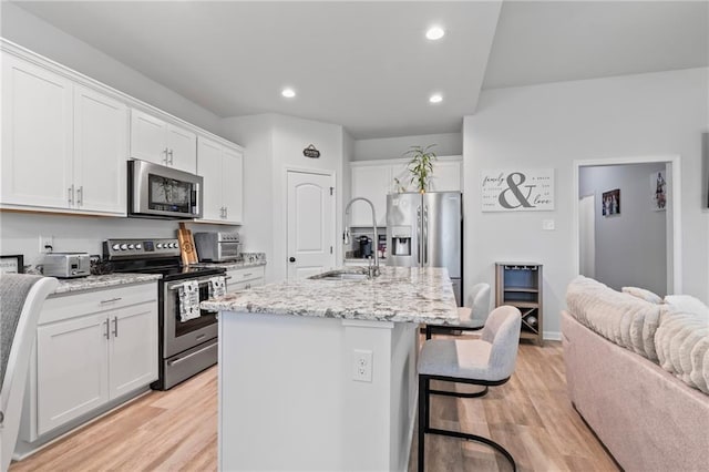 16168 S Trace Ext, Ponchatoula, LA 70454 - kitchen featuring stainless steel appliances, a center island with sink, recessed lighting, white cabinetry, and light wood-style floors