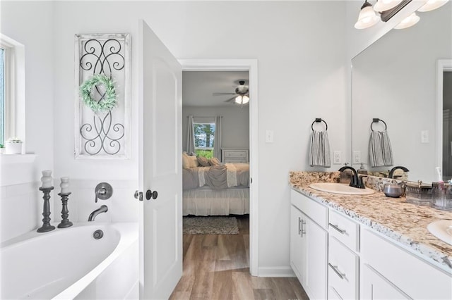 16168 S Trace Ext, Ponchatoula, LA 70454 - full bathroom with double vanity, connected bathroom, a bath, ceiling fan, and wood finished floors