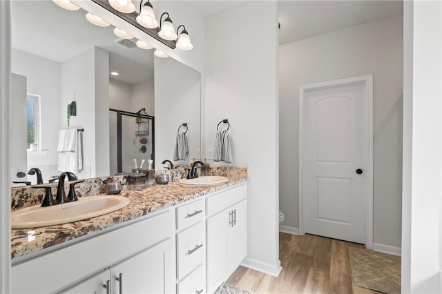 16168 S Trace Ext, Ponchatoula, LA 70454 - bathroom featuring double vanity, wood finished floors, and a stall shower
