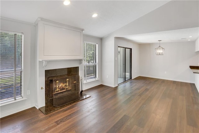 640 Tete Lours Dr Unit 1, Mandeville, LA 70471 - unfurnished living room featuring a lit fireplace, dark wood-style floors, vaulted ceiling, crown molding, and a chandelier