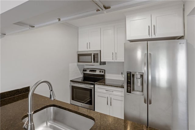 640 Tete Lours Dr Unit 1, Mandeville, LA 70471 - kitchen featuring appliances with stainless steel finishes, dark stone counters, white cabinets, and tasteful backsplash