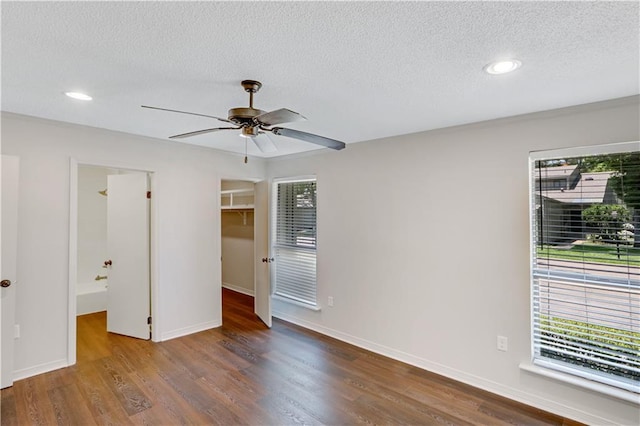640 Tete Lours Dr Unit 1, Mandeville, LA 70471 - unfurnished bedroom with a textured ceiling, a spacious closet, wood finished floors, recessed lighting, and ensuite bathroom