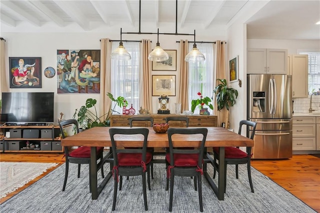 827 Port St, New Orleans, LA 70117 - dining space with light wood-type flooring and beam ceiling