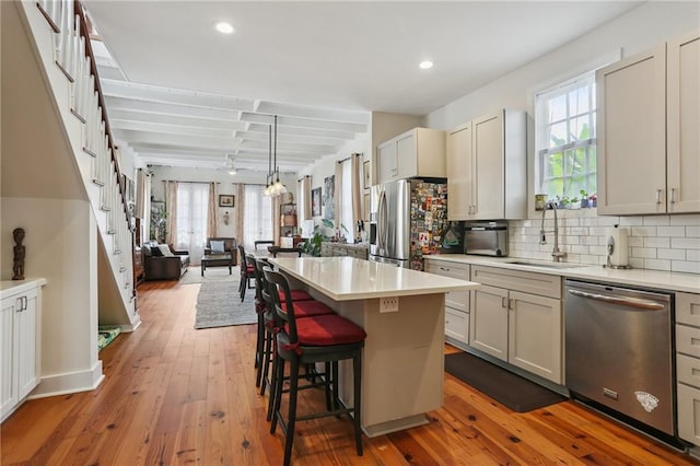 827 Port St, New Orleans, LA 70117 - kitchen with appliances with stainless steel finishes, light countertops, a center island, decorative backsplash, and recessed lighting