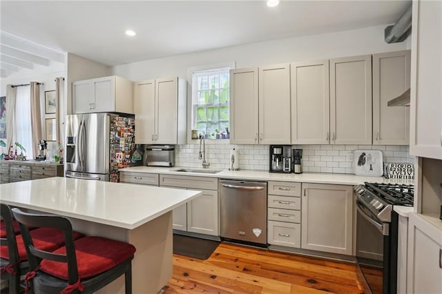 827 Port St, New Orleans, LA 70117 - kitchen with stainless steel appliances, light countertops, tasteful backsplash, light wood-style flooring, and recessed lighting