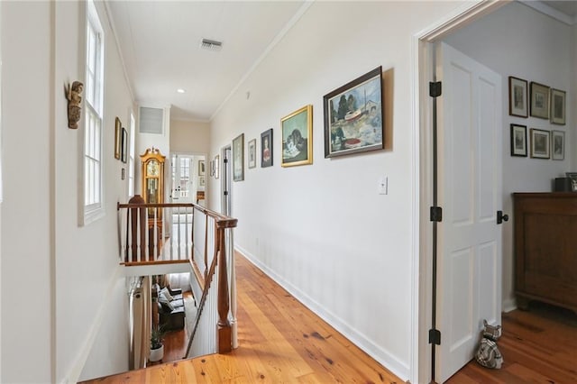 827 Port St, New Orleans, LA 70117 - hallway with light wood finished floors, crown molding, and an upstairs landing